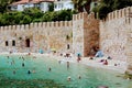 Vacationers bathe and sunbathe against the background of the ancient fortress wall Alanya, Turkey