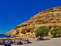 Vacationers on the beach of Matala, in the background the famous caves in the rock