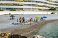 Vacationers on the beautiful pebble beach of the Cote d`Azur on a sunny morning. France.