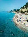 Vacationers on the free sandy and pebble Capo San Donato or Castelleto Pier Beach. Finale Ligure, Italy. Copy space