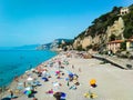 Vacationers on the free sandy and pebble Capo San Donato or Castelleto Pier Beach. Finale Ligure, Italy. Copy space
