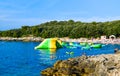 Vacationers on the free stony and pebble Ambrela beach of the Adriatic Sea on a summer sunny day. Pula, Croatia