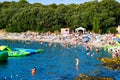 Vacationers on the free stony and pebble Ambrela beach of the Adriatic Sea on a summer sunny day. Pula, Croatia