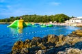 Vacationers on the free stony and pebble Ambrela beach of the Adriatic Sea on a summer sunny day. Pula, Croatia