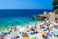 Vacationers on the free stony and pebble Hawaii beach of the Adriatic Sea. Pula, Croatia