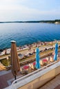 Vacationers on the free stony and terraced Brioni beach of the Adriatic Sea. Pula, Croatia