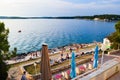 Vacationers on the free stony and terraced Brioni beach of the Adriatic Sea. Pula, Croatia