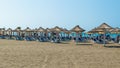 Vacationers on sand Long Beach (Velika plaza) with umbrellas and sun loungers. Ulcinj, Montenegro. Adriatic Sea