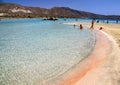 Vacationers at shallow clear sea with pink sand at Elafonisi, Crete island in Greece