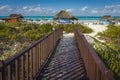 Vacationers sunbathing around hatched roof shelters on the beautiful beach of Santa Maria, Cuba