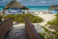 Vacationers sunbathing around hatched roof shelters on the beautiful beach of Santa Maria, Cuba