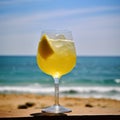 Vacations, relax concept. Yellow beverage cocktail with lemon slice standingon summer sea, ocean background. Selective