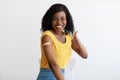 Vaccinated African Lady Gesturing Thumbs-Up Showing Arm Vaccination In Studio