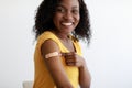 Vaccinated African Woman Showing Arm After Vaccination Over Gray Background