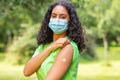 Vaccinated African American female young woman wearing face mask and vaccine band aid Royalty Free Stock Photo