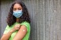 Vaccinated African American female young woman wearing face mask and vaccine band aid Royalty Free Stock Photo