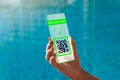 Vaccinated person using futuristic mobile phone application to show proof of immunity at the swimming pool .