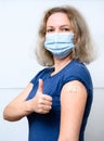 Vaccinated young woman showing shoulder with plaster