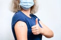 Vaccinated young woman showing shoulder with plaster