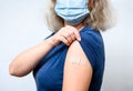 Vaccinated young woman showing shoulder with plaster