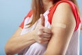 Vaccination COVID-19. Vaccinated woman gesturing with thumbs up showing hand with plaster cast after injection of coronavirus