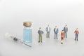 Vaccination and herd immunity concept with people standing beside syringe and vaccine bottle Royalty Free Stock Photo