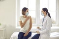 Professional nurse talking to a young woman who`s about to get an antiviral vaccine Royalty Free Stock Photo