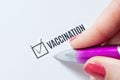 Vaccination is a positive answer in the questionnaire. The hand of a young woman fills the checklist and puts a chatter on the