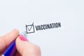 Vaccination is a positive answer in the questionnaire. The hand of a young woman fills the checklist and puts a chatter on the