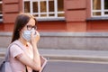 Vaccination in schools and colleges,a teenage student in a medical mask with a backpack and textbooks stands next to the