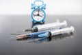 Vaccination time. Vaccine in vial with syringe on clock background. Prevention immunization illness