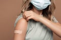 Vaccination campaign from covid-19 disease: female in medical face mask show arm getting vaccine Royalty Free Stock Photo