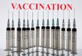 Vaccination word and medical syringes in the white background