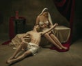 Modern remake of classical artwork with coronavirus theme - young medieval couple on dark background Royalty Free Stock Photo