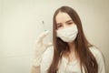 Vaccinations and vaccines. Girl in a medical mask with a syringe in her hands in a hospital Royalty Free Stock Photo