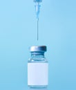 Vaccine in a bottle with a syringe on a blue background.The concept of medicine  healthcare and science.Coronavirus vaccine.Copy Royalty Free Stock Photo