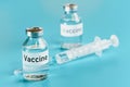 Vaccine bottle vials with hypodermic syringe needle near cyan background Royalty Free Stock Photo