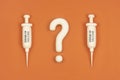 Vaccine hesitancy concept, syringes with vaccine and question mark. Doubts and hesitations about covid-19 vaccine, risks and side