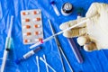 Vaccine in the needle, hand with glove holding needle, drugs and ampule