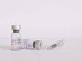 Vaccine Vials for Codiv-19 or Coronavirus with a syringe in studio set with plain white minimalist background