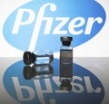 Vaccine vials with Pfizer logo in the background.