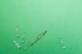 Vaccine vials and syringe on a green background with copy space.