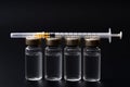 Vaccines, botulinum toxin and insulin ampules concept theme with glass vials with clear liquid next to a syringe and a hypodermic