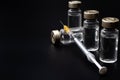 Vaccines, botulinum toxin and insulin ampules concept theme with glass vials with clear liquid next to a syringe and a hypodermic