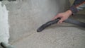 Vacuum cleaner construction on the background of concrete walls and floors. A worker removes dust with a vacuum cleaner from a Royalty Free Stock Photo