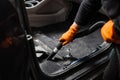 Vacuum cleaning of dirty car floor with removed seats in detailing service. Worker of detailing service is using vacuum Royalty Free Stock Photo