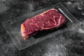 Vacuum packed beef, on black dark stone table background, with copy space for text Royalty Free Stock Photo
