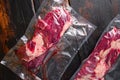 Vacuum packed Chuck roll  beef steak on dark old wooden background, close up top view Royalty Free Stock Photo