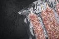 Vacuum packed raw meat skewers, on black dark stone table background, top view flat lay, with copy space for text Royalty Free Stock Photo