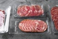Vacuum packed sausage coppa sliced salami, on gray stone table background Royalty Free Stock Photo